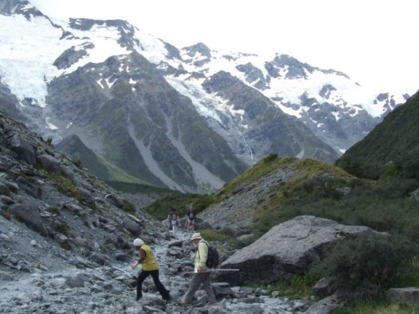 Hikers carefully crossing the stony creek bed