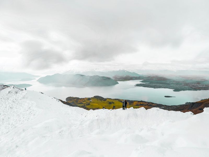 Hikers in front of me on Roys Peak in winter with snow on top