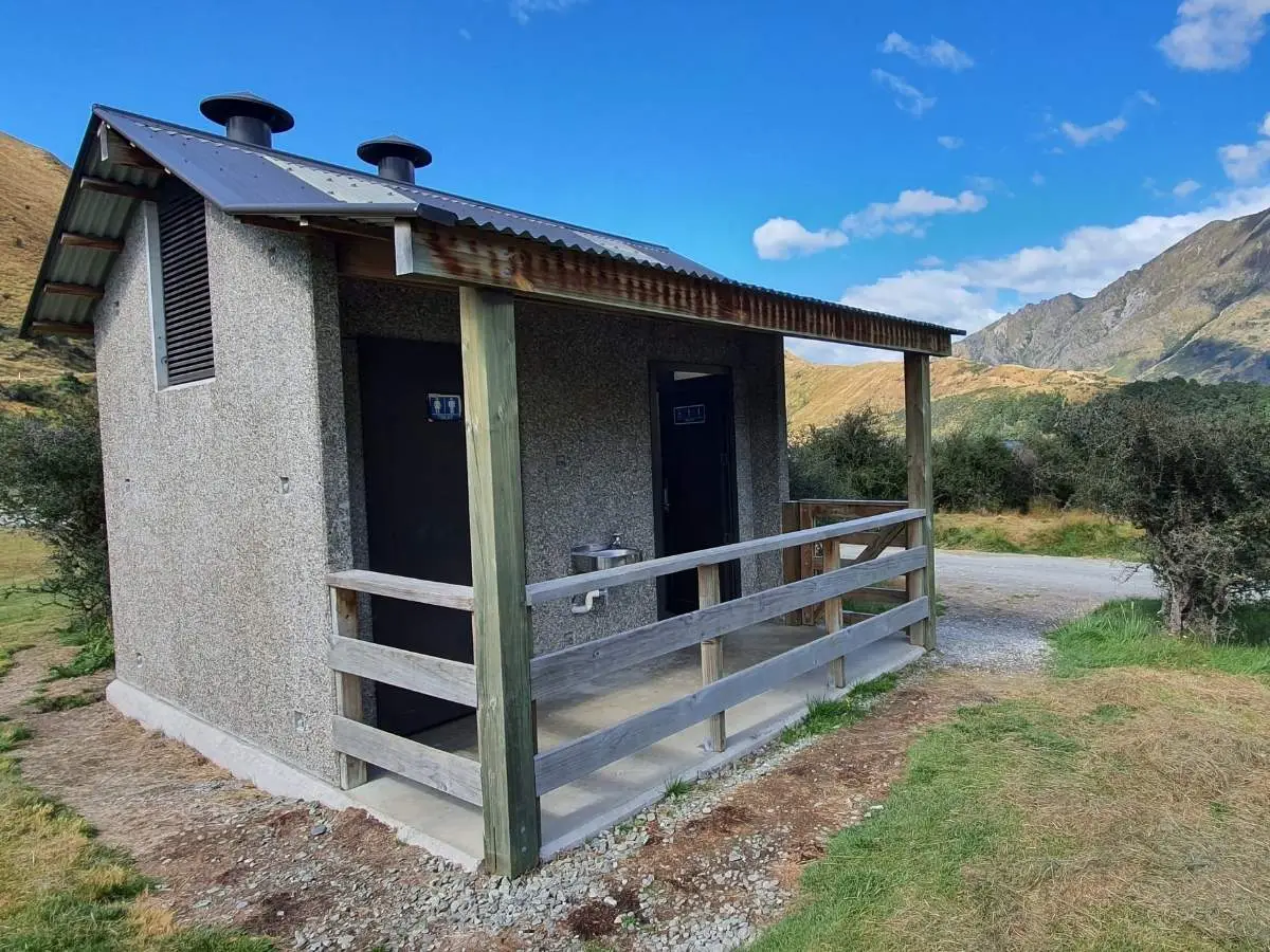 Public toilet block at Moke Lake Reserve with mountains behind