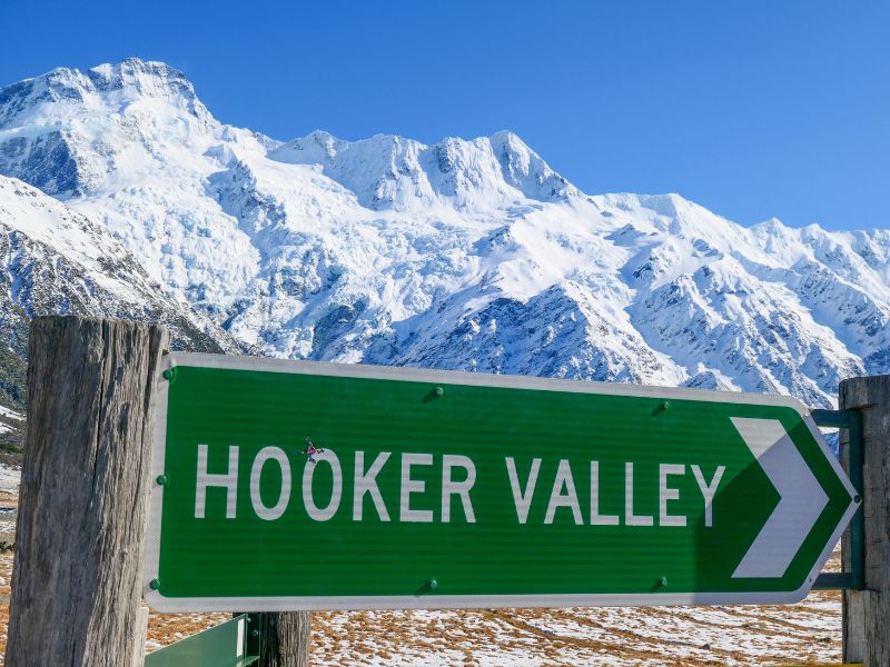 Road sign to Hooker Valley on a beautiful sunny day with Mount Cook in the background