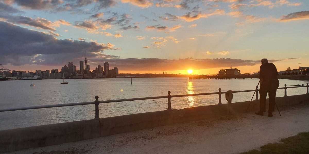 Looking out to Auckland city across the harbour from Devonport with a beautiful sunset - Copyright Freewalks.nz