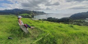 Sandra sitting on a bench seat on a walk in Leigh in the Auckland Region