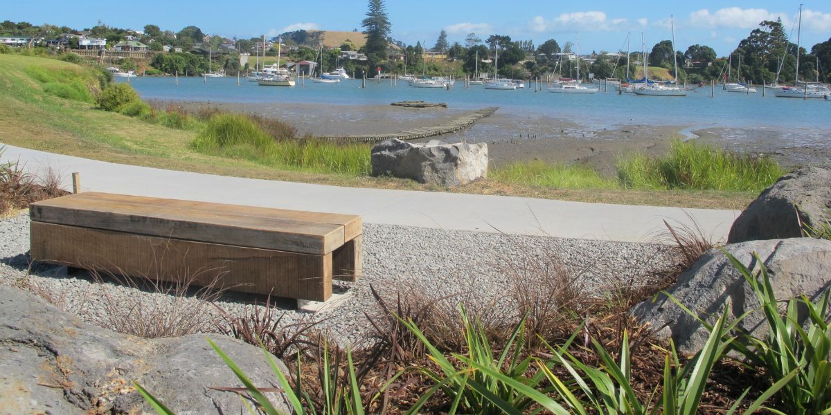 Bench seat on the Pakuranga walkway looking out to the harbour with the boats