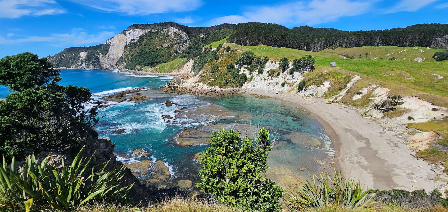 Rocky bay with clear turquoise water and white cliffs at Parapara Bay, Great Mercury Island Ahuahu