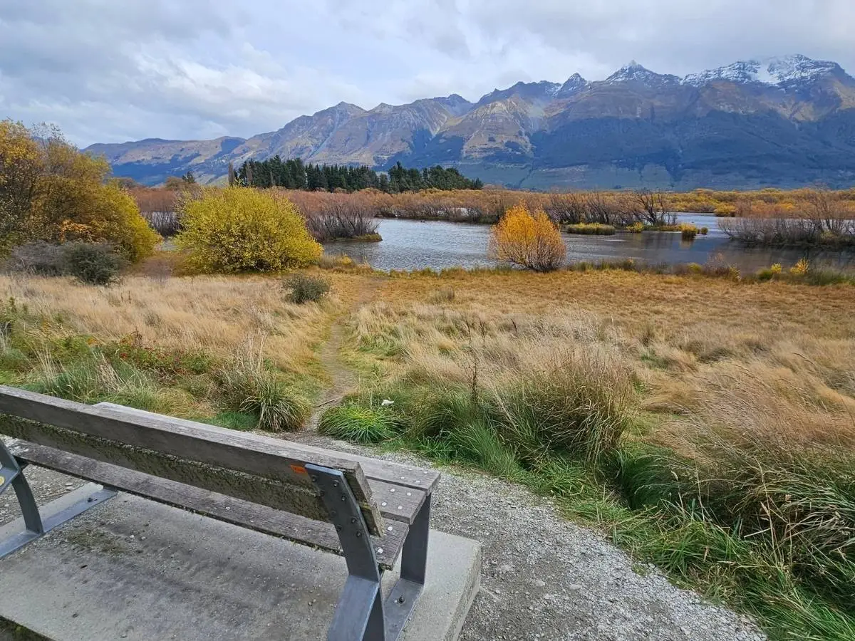 Bench overlooking Glenorchy Lagoon wetlands with snow-capped Mount Earnslaw in the background